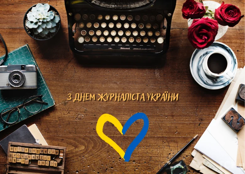 Святковий стіл з різними предметами для журналіста та українським серцем