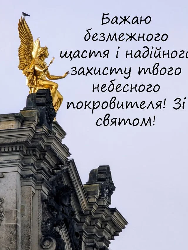 Золотий ангел на даху будівлі з привітанням у день ангела українською.