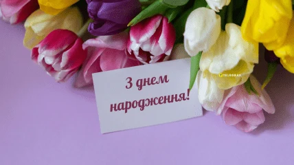Квіти та картка з привітанням на день народження українською.