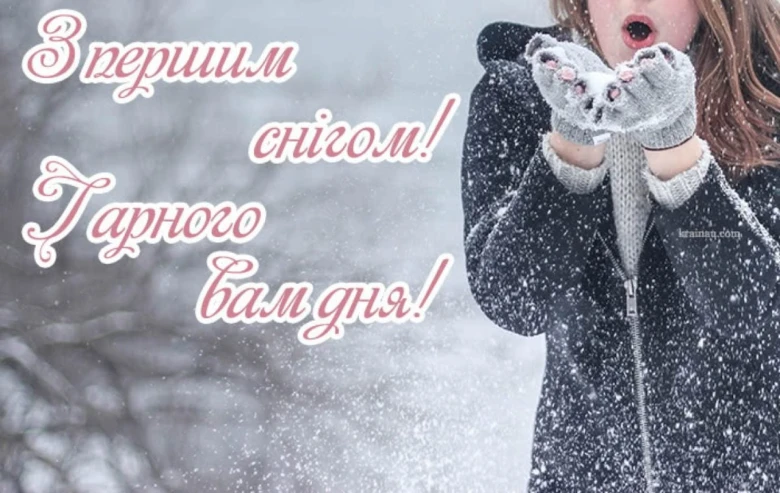 Дівчина дме сніжинки з рук на фоні першого снігу.