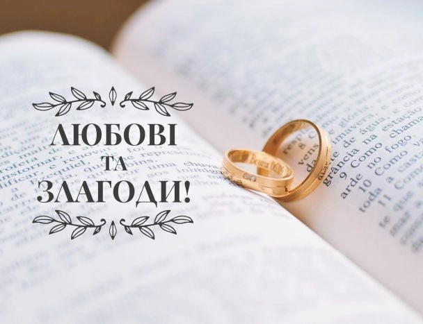 Книга з двома золотими обручальними кільцями та українським привітанням.