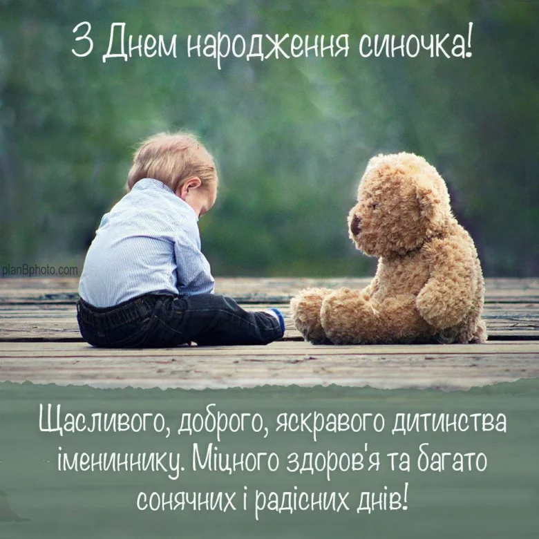 Дитина та ведмедик на дошці з привітанням.