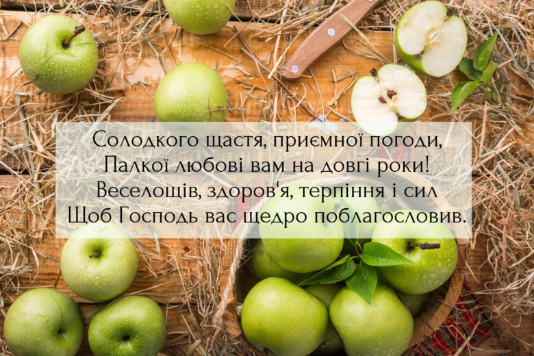 Зелені яблука на дерев'яній дошці з привітанням для Яблучного Спасу.